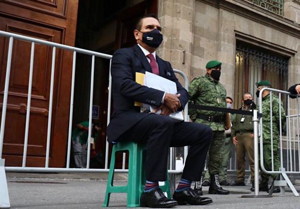 Silvano Aureoles, con más de una hora de espera, sentado afuera de Palacio Nacional, este martes.