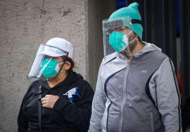 Transeúntes de Ciudad de México portan cubreboca y careta para prevenir contagio de Covid-19.