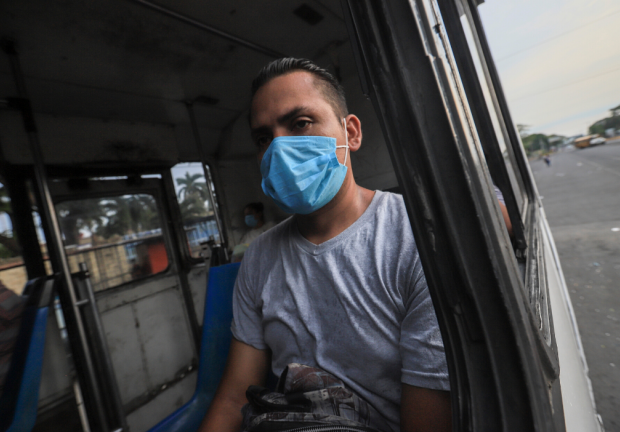 Un hombre con mascarilla para evitar el contagio del COVID-19 viaja en un camión el 11 de mayo de 2020 en Managua, Nicaragua.