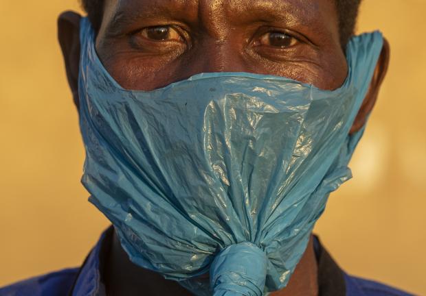 Un hombre se cubre el rostro con una bolsa de plástico en Katlehong, al este de Johannesburgo, Sudáfrica el 6 de mayo del 2020.
