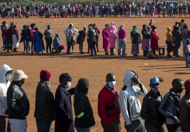 Personas afectadas por la recesión económica del COVID-19 hacen fila para recibir donaciones de alimentos cerca de Laudium, suroeste de Pretoria, Sudáfrica, el 20 de mayo de 2020.
