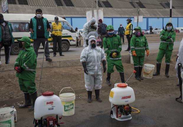 Trabajadores desinfectan un área en un mercado popular para ayudar a prevenir la propagación de COVID-19, en Lima, Perú, el 2 de junio de 2020.
