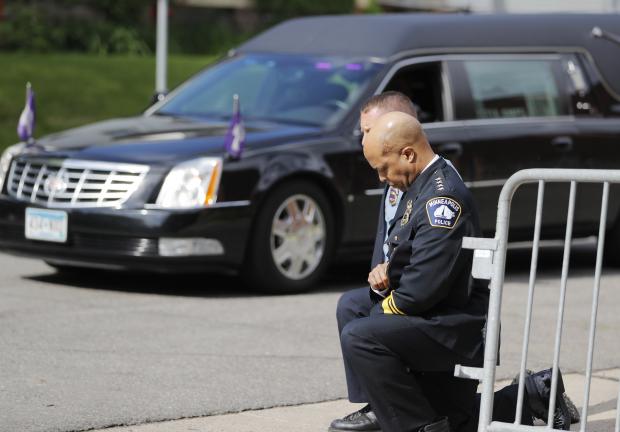 Agentes de la policía, incluido el jefe de la policía de Minneapolis Medaria Arradondo, se arrodillan mientras arriba el cuerpo de George Floyd previo a su funeral el 4 de junio de 2020.