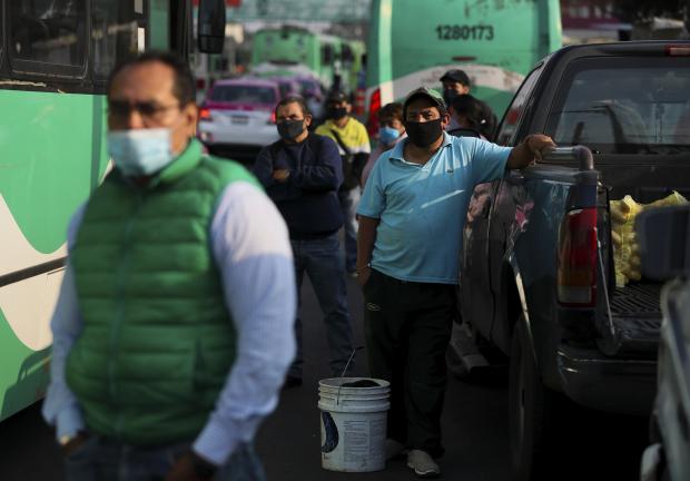 Pasajeros que esperan subir al transporte público usan cubrebocas en medio de la pandemia en la Ciudad de México, el 1 de junio de 2020.