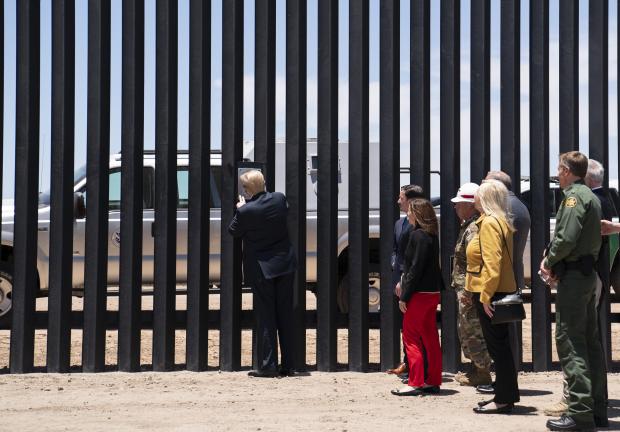 El presidente Donald Trump pone su firma en una parte del muro fronterizo durante un recorrido en San Luis, Arizona, el 23 de junio de 2020.
