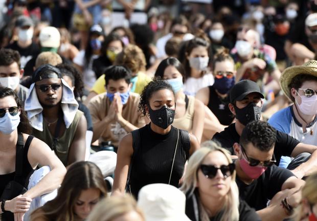 Personas participan en un momento de silencio, el viernes 19 de junio de 2020, en Los Ángeles.