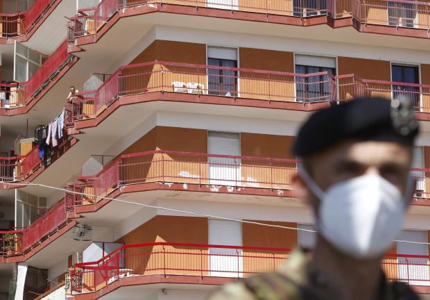 Un soldado está frente a un edificio donde se han registrado decenas de casos de COVID-19  al sur de Italia, el26 de junio de 2020.