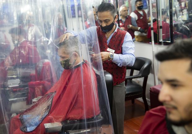 Hombre con cubrebocas mientras le cortan el cabello, el 22 de junio de 2020 en la peluquería Ace of Cuts, en Nueva York.