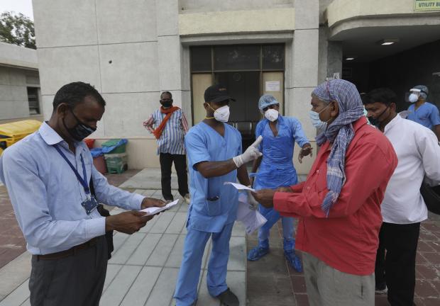 Trabajadores de salud dan informes de personas que se hicieron la prueba COVID-19 en un hospital de Nueva Delhi, India, el 6 de julio de 2020.