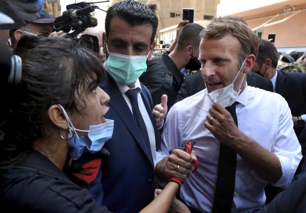 El presidente francés, Emmanuel Macron, habla con una mujer mientras visita el barrio de Gemayzeh, en Beirut, Líbano, el 6 de agosto de 2020.