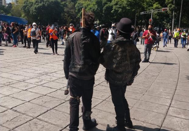 Dos hombres miran a las manifestantes de la marcha.