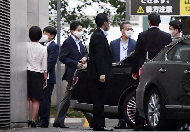 El primer ministro se sube a un automóvil tras salir del hospital.