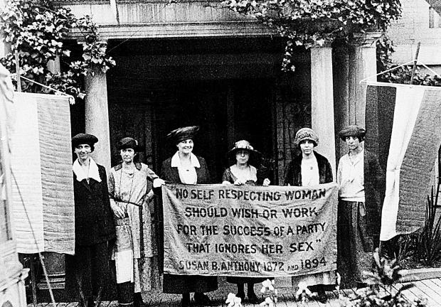 Foto de junio de 1920, la presidenta Alice Paul  y las oficiales del Partido Nacional de la Mujer sostienen una pancarta con una cita de Susan B. Anthony frente a la sede del NWP en Washington.