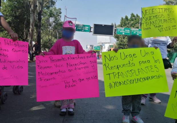 Niños con cáncer sostienen pancartas durante la manifestación.