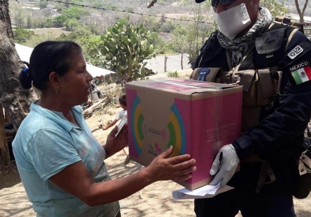 Un brigadista entrega apoyos sociales en Michoacán.