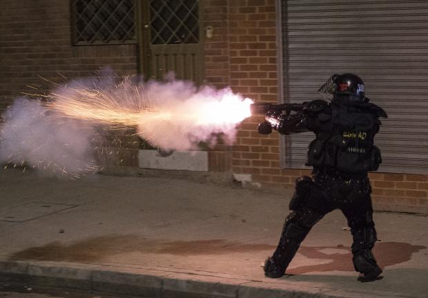 Un policía lanza gases lacrimógenos contra manifestante, en Bogotá, el miércoles.