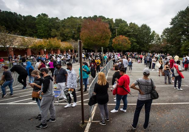 Cientos de personas esperan en fila para votar el lunes 12 de octubre de 2020 en Marietta, Georgia, para votar por anticipado..