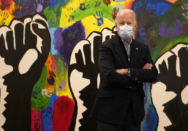 El candidato presidencial demócrata, el exvicepresidente Joe Biden, se detiene frente a un mural durante una visita al centro para adolescentes The Warehouse en Wilmington, Delaware, el martes 3 de noviembre de 2020.
