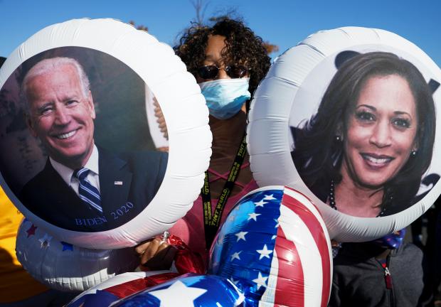 Una simpatizante del candidato demócrata a la presidencia de Estados Unidos, Joe Biden, sostiene globos con las caras de Joe Biden y Kamala Harris..