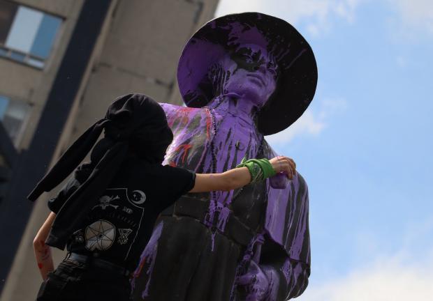 Una mujer pinta una estatua, durante una marcha para exigir justicia por una menor que presuntamente fue víctima de abuso sexual por parte de policías, en agosto de 2020.