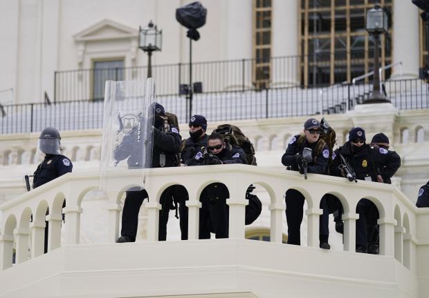 La policía vigila a los manifestantes que intentaron atravesar una barrera policial el miércoles 6 de enero de 2021 en el Capitolio en Washington