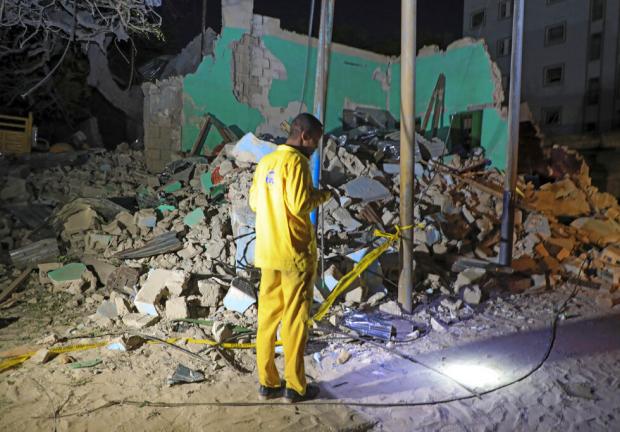 Un hombre observa la escena de destrucción tras la explosión del coche bomba.