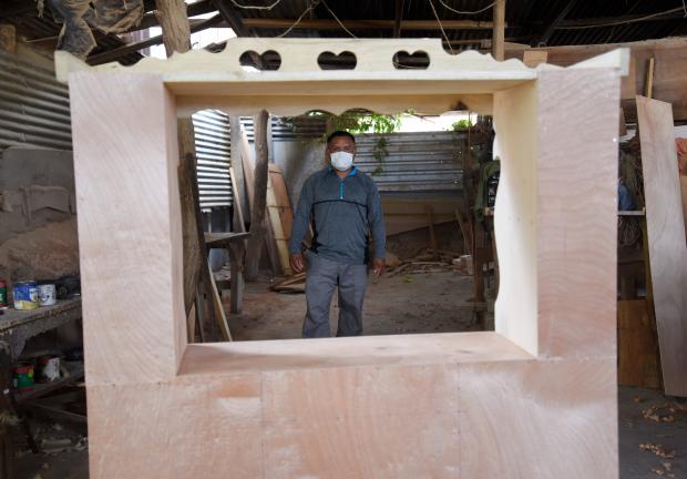 William López, carpintero originario de El Salvador, construyó un pupitre especial para su hija. Foto: EFE