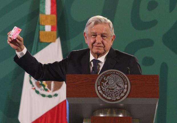 El presidente de México, Andrés Manuel López Obrador (AMLO) muestra una tarjetas rosa que ofrece el candidato del PRI en Nuevo León, Adrián de la Garza.