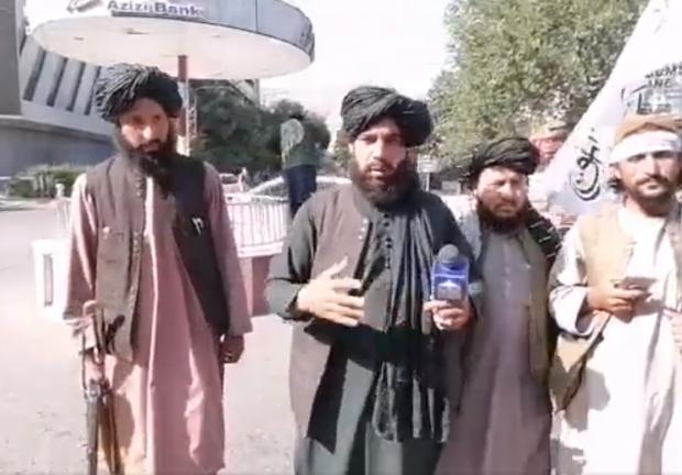 Reporteros talibanes con rifle preguntan a la gente si es feliz