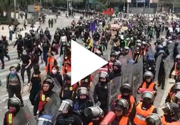 Feministas marchando hacia el Zócalo capitalino resguardadas por policías de la CDMX.