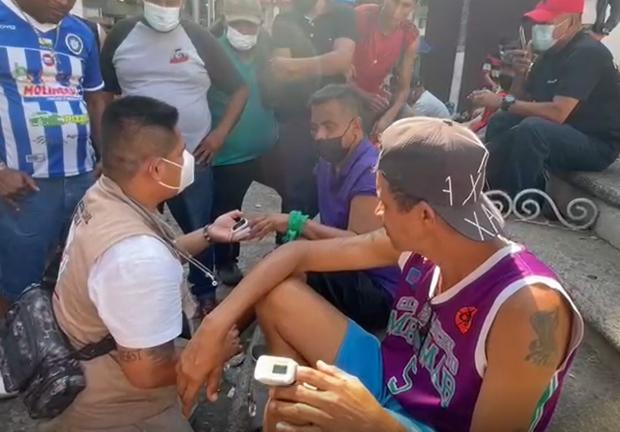 Dos migrante son atendidos por un médico tras presentar malestares derivados de la huelga de hambre en Chiapas.