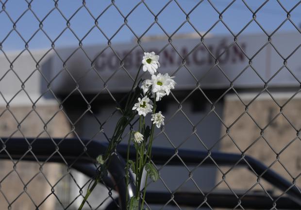 Flores marchitas cuelgan de la cerca frente a un centro de detención de inmigrantes donde decenas de personas murieron en un incendio en Ciudad Juárez, México,