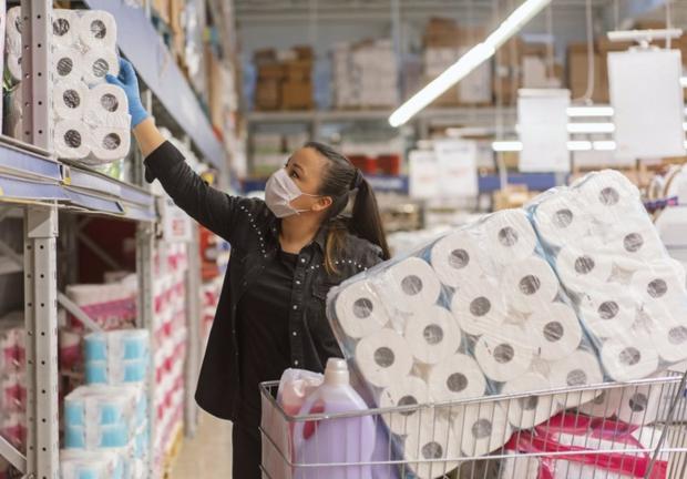Mujer comprando papel higiénico en el supermercado.