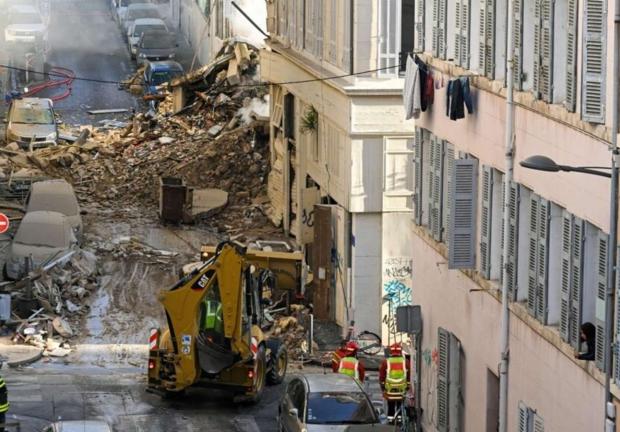 Bomberos junto a un camión trasladando escombros donde se derrumbó un edificio en Marsella, sur de Francia, el 9 de abril de 2023.