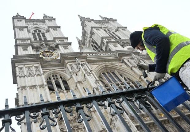 Un trabajador pinta barandillas en preparación para la coronación del rey Carlos III, en las afueras de la Abadía de Westminster en Londres, Gran Bretaña.
