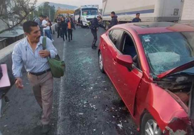 Una persona se asoma dentro del vehículo de la persona que provocó el accidente en la México-Puebla, que perdió la vida.