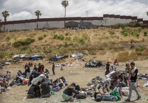 Migrantes en el muro fronterizo entre Estados Unidos y México.