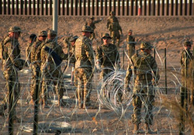 Migrantes en el muro fronterizo entre Estados Unidos y México.