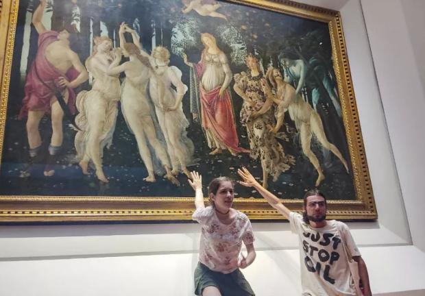 Dos activistas de la organización ambiental Ultima Generazione (Ultima Generación) que afirmaron estar pegados al vidrio que protege la obra maestra del renacentista italiano Sandro Botticelli “La primavera” en la Galería Uffizi de Florencia en Italia el viernes 22 de julio de 2022.