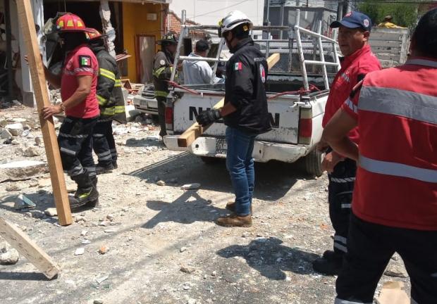 Bomberos retiran escombros que dejó una explosión por acumulación de gas en las calles del centro de Toluca.