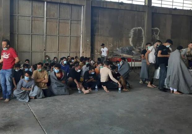 Sobrevivientes de un naufragio, sentados en un almacén en el puerto de Kalamata, a unos 240 kms (150 millas) al suroeste de Atenas, el 14 de junio de 2023.