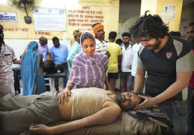 Meena Tiwari, al centro, llora frente al cuerpo de su hijo Ashutosh Tiwari, quien aparentemente murió de un golpe de calor en un hospital del gobierno distrital, en el distrito de Ballia, el lunes 19 de junio de 2023, en el estado de Uttar Pradesh, India.