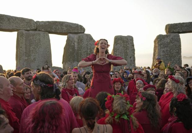 Gente reunida en el antiguo círculo de piedra de Stonehenge para celebrar el Solsticio de Verano, el día más largo del año, cerca de Salisbury, Inglaterra, el miércoles 21 de junio de 2023.