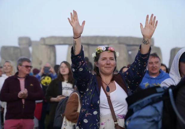 Gente reunida al amanecer en las celebraciones del Solsticio de Verano en Stonehenge, en Wiltshire, Inglaterra, el miércoles 21 de junio de 2023.