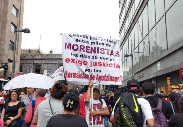 Un hombre lleva una pancarta donde exige justicia por el caso de los 43 desaparecidos de Ayotzinapa
