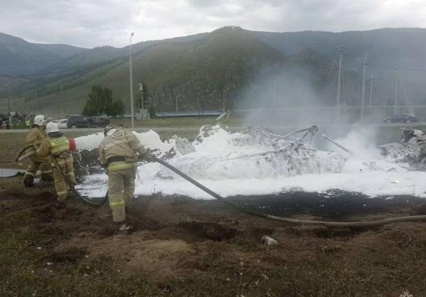 Bomberos apagan un helicóptero Mi-8 después del accidente cerca de la aldea de Tyungur, República de Altai, en el sur de Siberia.