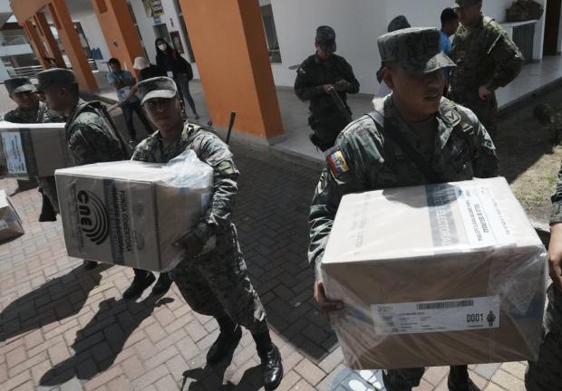 Elementos del Ejército de Ecuador entregan materiales electorales en un centro de votaciones en Quito este domingo 20 de agosto.