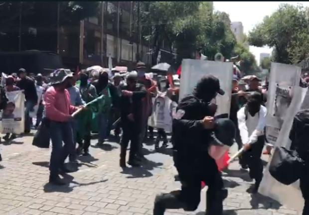 Durante su paso hacía el Zócalo de la Ciudad de México, algunos integrantes de la marcha por el Día Internacional de las Víctimas de Desapariciones Forzadas se enfrentaron con policías de la capital.