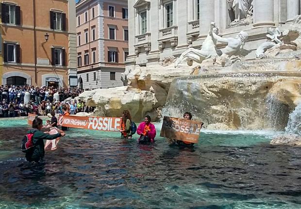 Activistas de Ultima Generación vacían liquido vegetal negro en el agua de la Fontana di Trevi, en Roma, Italia.