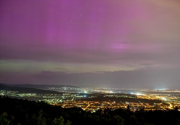 Se ve una aurora boreal sobre Urom y Pilisborosjeno, desde la colina Harmashatar en Budapest, Hungría.